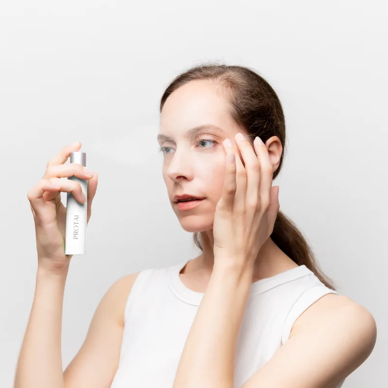 Woman holding PROTAI mist beside her face