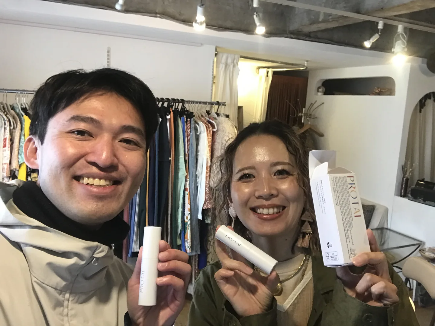 Two people displaying PROTAI bottles and packaging