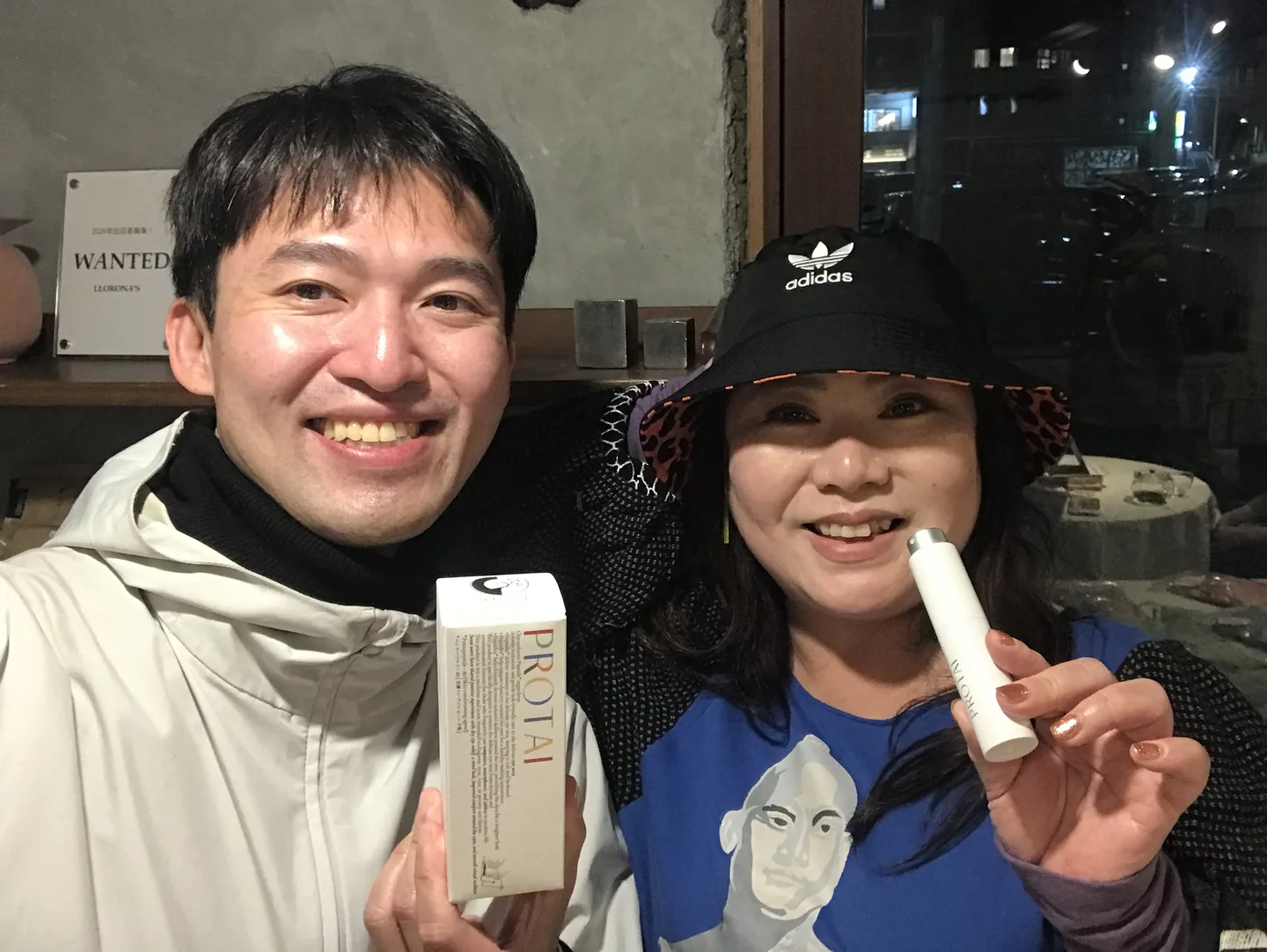 Two people displaying PROTAI products at night