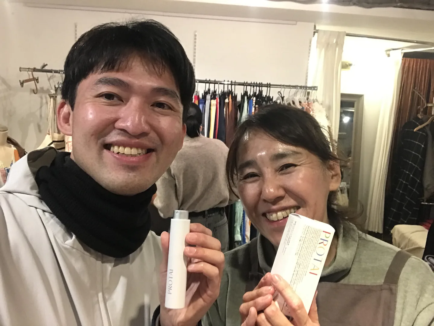 Two people holding PROTAI bottles and packaging