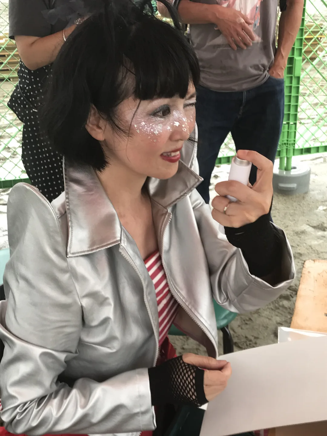 Woman applying PROTAI mist near her face outdoors